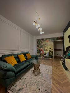 un soggiorno con divano verde e cuscini gialli di Nivas Apartments-Palace of Culture a Iaşi