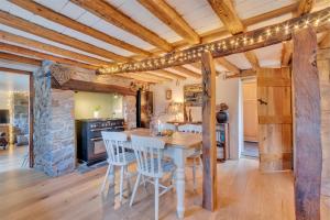 a kitchen with wooden ceilings and a table and chairs at Rock Cottage in Llanfyllin