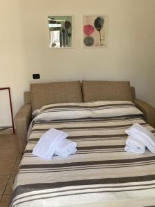 a bed with two white towels on top of it at Dimora Angolo15 in Cisternino
