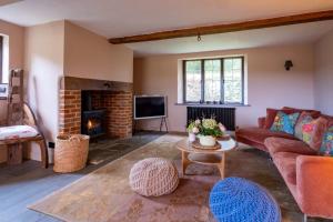 a living room with a couch and a fireplace at Pond House in Lymington