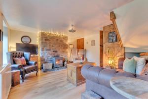 a living room with a couch and a fireplace at Rock Cottage in Llanfyllin