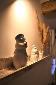 un estante con tres muñecos de nieve de cerámica. en Michówka, en Mikoszewo
