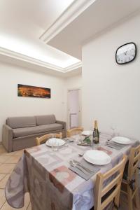 a dining room with a table and a couch at Anzio- central holiday house. in Anzio