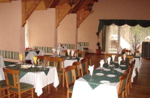a dining room with tables with green and white table settings at Senieji Bačkonys in Bačkonys