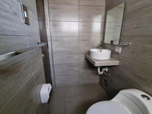 uma casa de banho com um lavatório, um WC e um espelho. em Hotel Rey em Huancayo