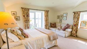 a bedroom with a bed and a lamp and a couch at Ty Gwair in Pentraeth
