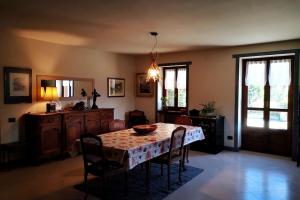 a dining room with a table and chairs in a room at La maison de Carmen in Aosta