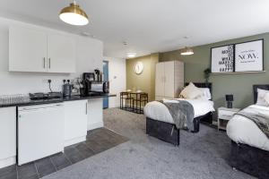 a kitchen and a living room with two beds at City Centre Studio 3 with Kitchenette, Free Wifi and Smart TV with Netflix by Yoko Property in Middlesbrough