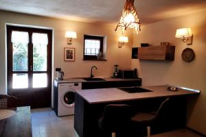 uma cozinha com um lavatório e uma máquina de lavar roupa em La maison de Carmen em Aosta