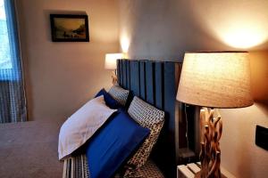 ein Schlafzimmer mit einem Bett und einer Lampe in der Unterkunft La maison de Carmen in Aosta