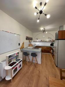 cocina con fregadero y encimera con taburetes en Central Retro Apartment en Sibiu