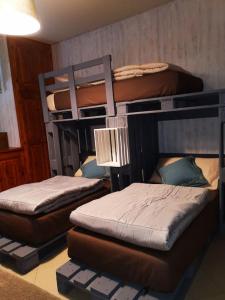 a room with three bunk beds in a room at La maison de Carmen in Aosta