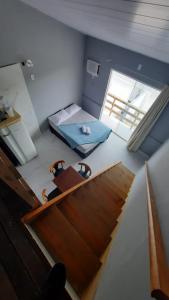 Habitación pequeña con cama y ventana en CK - APTO TIPO LOFT Individual ar, wifi, vaga, cozinha-, en Itapema
