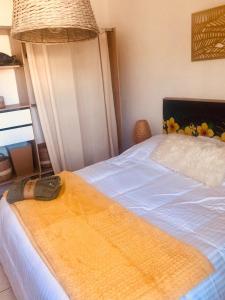 una camera da letto con un letto con una coperta gialla sopra di Le camélia a Tallard