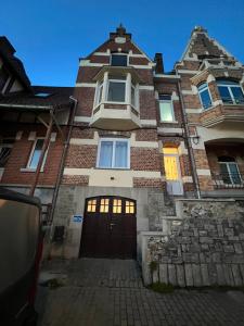 - un grand bâtiment en briques avec une porte d'entrée dans l'établissement Riverbank Guest House, à Namur