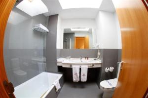a bathroom with a sink and a tub and a toilet at Colón Tuy in Tui +5 photos