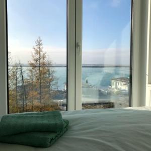 a bedroom with a large window with a view of the ocean at Casa Ida am Hainer See in Neukieritzsch