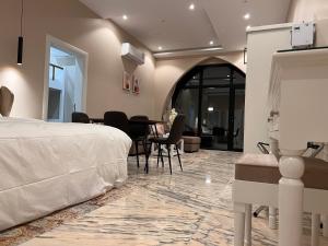 um quarto com uma cama, uma mesa e cadeiras em الأجنحة الرخامية فندقية em Buraidah