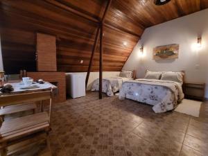 サン・ベント・ド・サプカイーにあるVilla das Palmeiras Chalés & Campingの広いベッドルーム(ベッド2台、テーブル付)