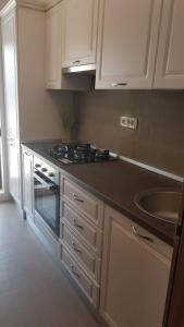 布加勒斯特的住宿－21 Residence Apartments，厨房配有白色橱柜和黑色台面