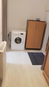uma lavandaria com uma máquina de lavar roupa num quarto em 21 Residence Apartments em Bucareste