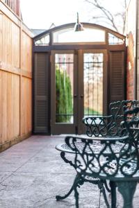 un banc et une table devant une porte dans l'établissement Henry House - Patio Suite - An Arrivals Stay, à Stratford