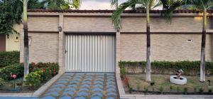 un bâtiment avec une porte de garage et des palmiers dans l'établissement Excelente Casa no Bairro Mundo Novo com piscina, à Manaus