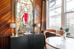 a dining room with a table and a stained glass window at Henry House - Patio Suite - An Arrivals Stay in Stratford
