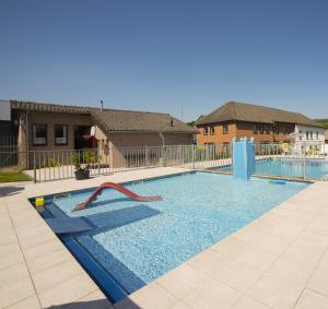 a swimming pool with a slide in the middle at Vakantie oord Zonnehoeve in Valkenburg