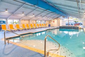 a large swimming pool with chairs and tables in a building at Fenwick Inn in Ocean City