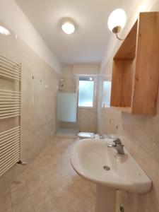 La salle de bains est pourvue d'un lavabo et d'une douche. dans l'établissement Case vacanza Erica Igea Marina, à Bellaria-Igea Marina