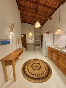 Casa Nature Atins في أتينز: مطبخ مع طاولة خشبية ومطبخ مع ثلاجة
