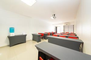 an empty waiting room with red chairs and desks at Slim São José Zion in São José