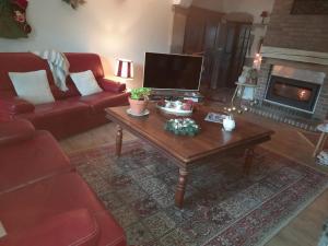 a living room with a red couch and a coffee table at chambre du jura in Saint-Germain-lès-Arlay