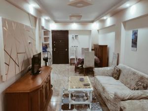 a living room with a couch and a tv at Flores casas de playa in Alexandria