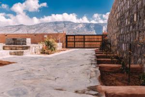 Sa‘ab Banī Khamīs的住宿－MountSun Stay Jabal Shams，一座以山为背景的建筑的庭院