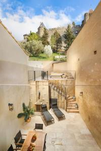 un balcón con mesa y sillas y un edificio en Longue Vie à la Reine - Piscine - Château, en Carcassonne