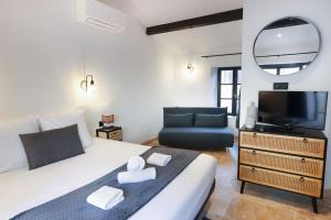 1 dormitorio con 1 cama, TV y sofá en Longue Vie à la Reine - Piscine - Château, en Carcassonne