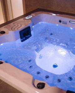 uma banheira de hidromassagem cheia de água azul na casa de banho em Luxury wellness apartment SHA em Osijek