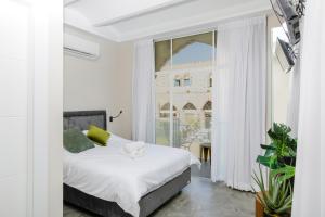 a bedroom with a bed and a large window at Jaffa House in Tel Aviv