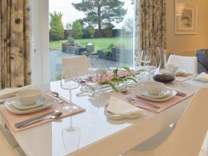 a dining room table with a white tablecloth and glasses and a table at Whitehouse Studio in Roslin