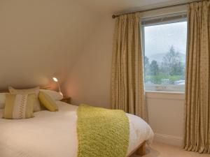 a bedroom with a bed and a large window at Whitehouse Studio in Roslin