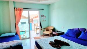 a bedroom with a bed and a door to a balcony at HappyLove1 in Ko Larn