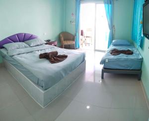 a bedroom with two beds and a television in it at HappyLove1 in Ko Larn