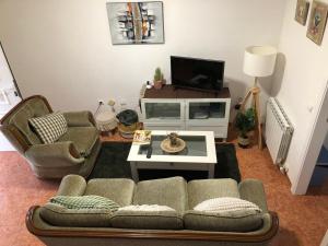 a living room with a couch and a tv at Señorin del Mar in Miami Platja