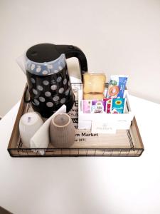 ein Tablett mit einer Kaffeekanne und anderen Artikeln auf dem Tisch in der Unterkunft Armonia family B&b in Crotone