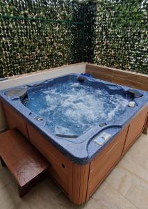 una bañera de hidromasaje en una caja de madera con agua en Bella Vista apartments with hot pool and jacuzzi, en Trogir