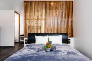 Un dormitorio con una cama grande con una planta. en House of Nomad - Adults only en Tamarindo