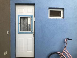 Ovnat的住宿－Beautiful Dead Sea Unit，蓝色的建筑,有白色的门和自行车