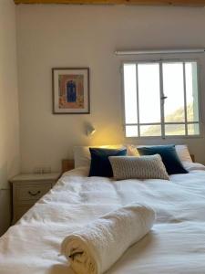 a bedroom with a large white bed with a window at Beautiful Dead Sea Unit in Ovnat